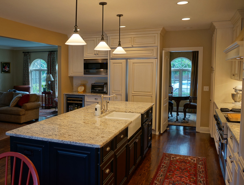 Example of a mid-sized classic l-shaped medium tone wood floor eat-in kitchen design in Chicago with a farmhouse sink, recessed-panel cabinets, dark wood cabinets, granite countertops, stainless steel appliances and an island