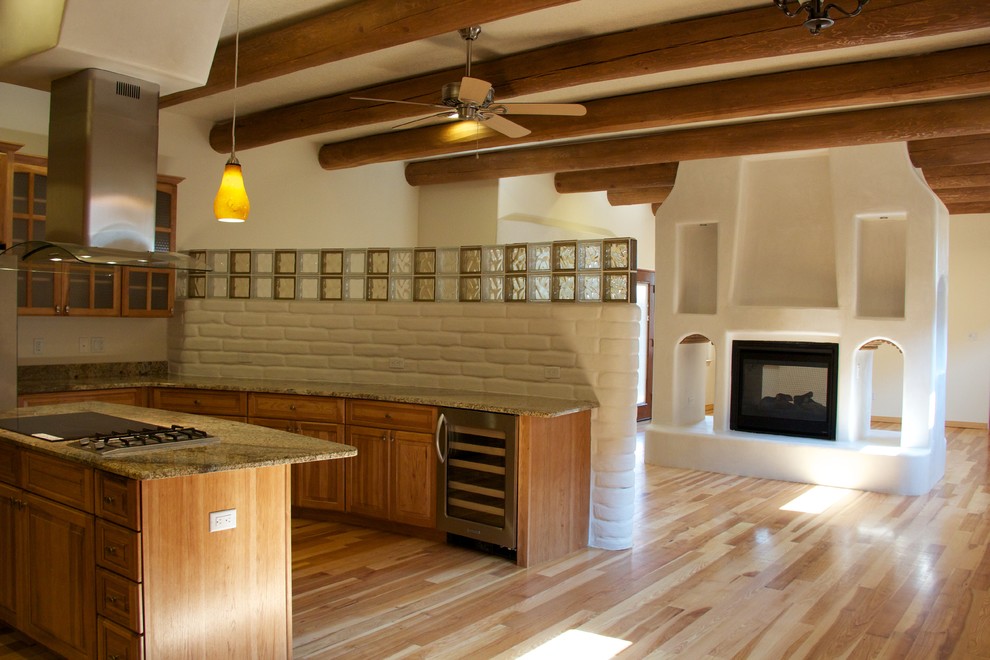 Mittelgroße Mediterrane Wohnküche in U-Form mit Unterbauwaschbecken, Schrankfronten im Shaker-Stil, hellbraunen Holzschränken, Granit-Arbeitsplatte, Küchengeräten aus Edelstahl, braunem Holzboden und Kücheninsel in Albuquerque