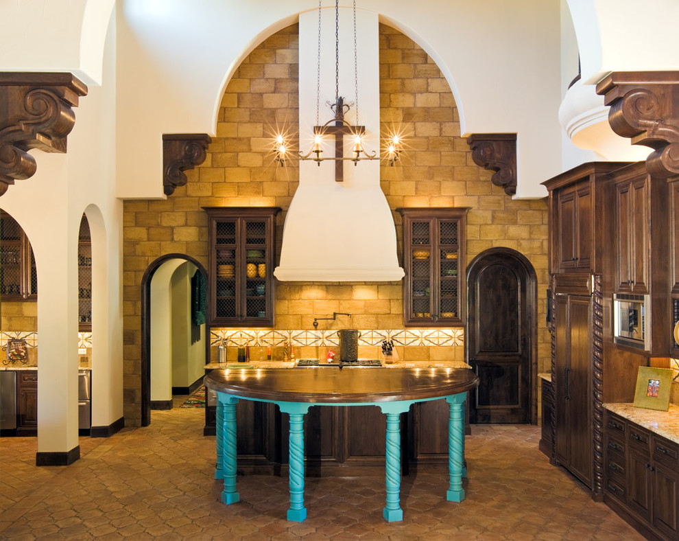 Пример оригинального дизайна: кухня в средиземноморском стиле с фасадами с выступающей филенкой, темными деревянными фасадами и техникой под мебельный фасад
