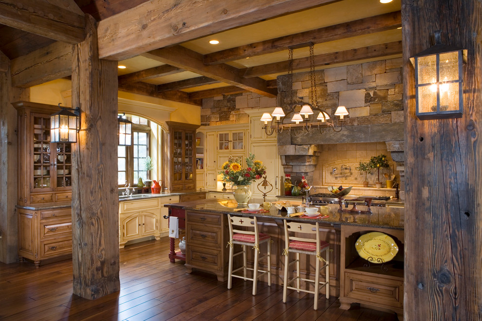 Imagen de cocina comedor rural con electrodomésticos con paneles y suelo de madera en tonos medios