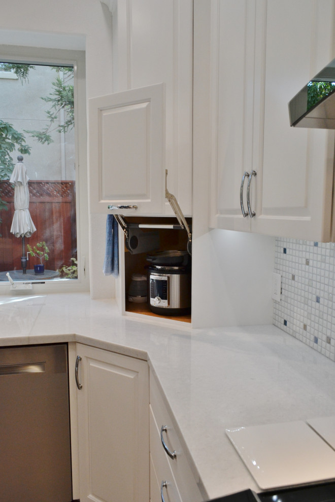 Idéer för att renovera ett stort vintage vit vitt kök, med en enkel diskho, luckor med upphöjd panel, vita skåp, bänkskiva i kvarts, blått stänkskydd, stänkskydd i mosaik, rostfria vitvaror, laminatgolv, en köksö och grått golv