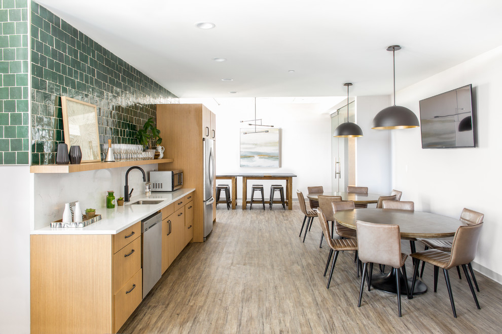 Photo of a scandinavian single-wall open plan kitchen in San Francisco with a submerged sink, flat-panel cabinets, medium wood cabinets, white splashback, stainless steel appliances, dark hardwood flooring and brown floors.