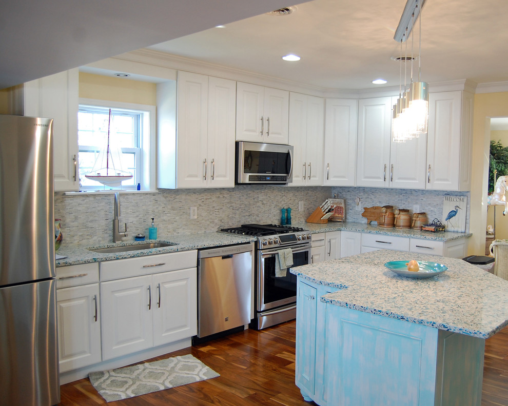 This is an example of a medium sized traditional l-shaped kitchen/diner in Baltimore with a submerged sink, raised-panel cabinets, white cabinets, engineered stone countertops, grey splashback, matchstick tiled splashback, stainless steel appliances, medium hardwood flooring and an island.