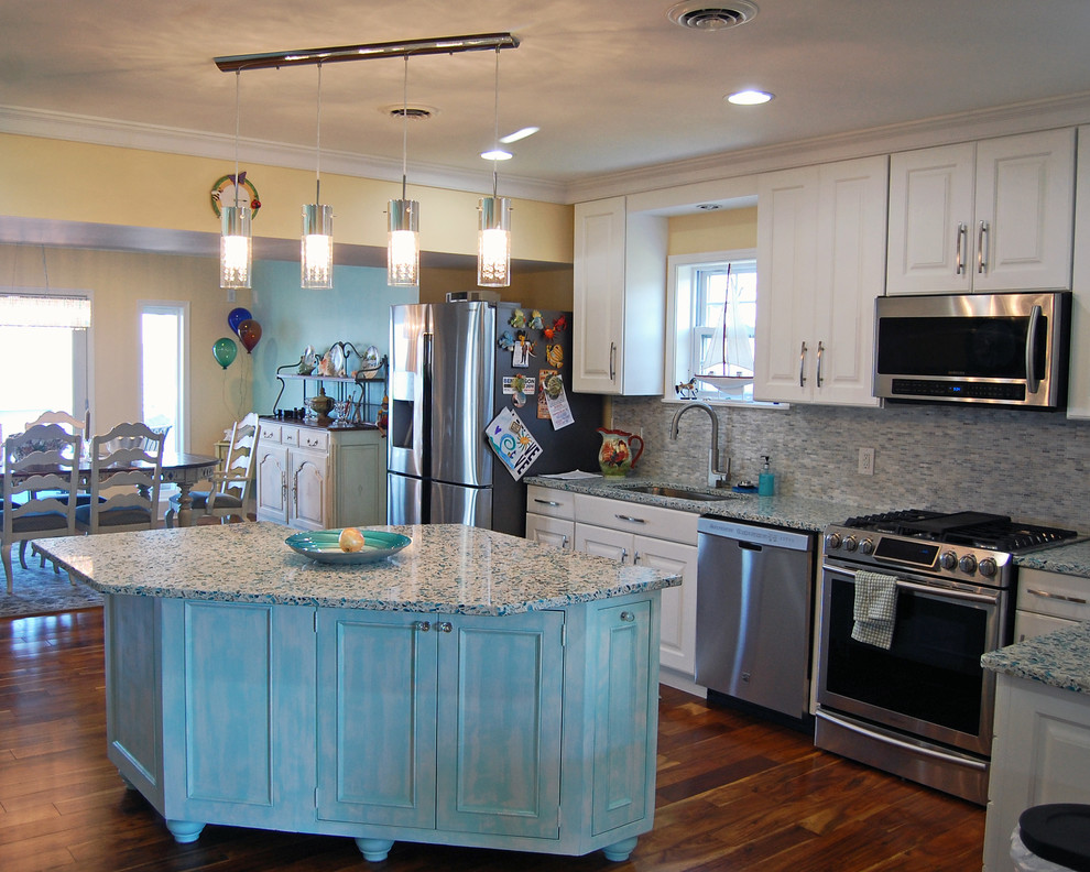 Bild på ett mellanstort vintage kök, med en undermonterad diskho, luckor med upphöjd panel, vita skåp, bänkskiva i kvarts, grått stänkskydd, stänkskydd i stickkakel, rostfria vitvaror, mellanmörkt trägolv och en köksö