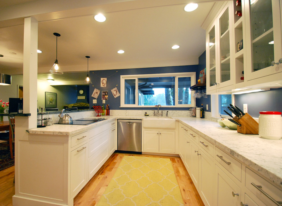 Photo of a medium sized modern u-shaped kitchen in Other with flat-panel cabinets, white cabinets, marble worktops, stainless steel appliances and light hardwood flooring.
