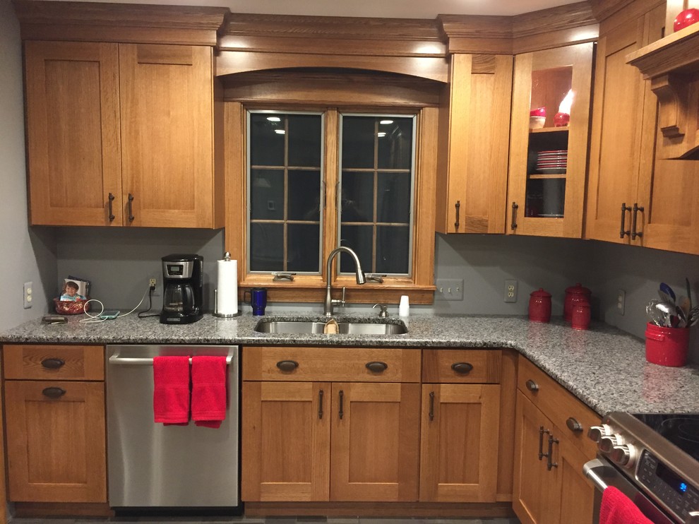 Foto på ett mellanstort lantligt grå kök, med en undermonterad diskho, skåp i shakerstil, skåp i mellenmörkt trä, granitbänkskiva, rostfria vitvaror, klinkergolv i porslin, en köksö och grått golv
