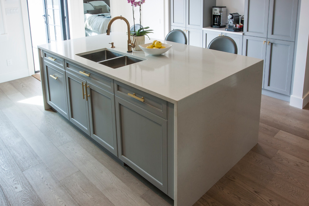 This is an example of a large classic l-shaped kitchen/diner in Vancouver with a submerged sink, shaker cabinets, engineered stone countertops, grey splashback, stone tiled splashback, integrated appliances and an island.