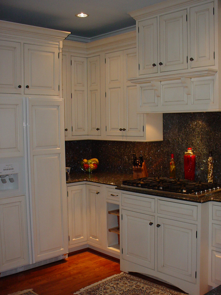 Foto på ett vintage kök, med en rustik diskho, luckor med upphöjd panel, vita skåp, granitbänkskiva, blått stänkskydd, stänkskydd i sten och integrerade vitvaror