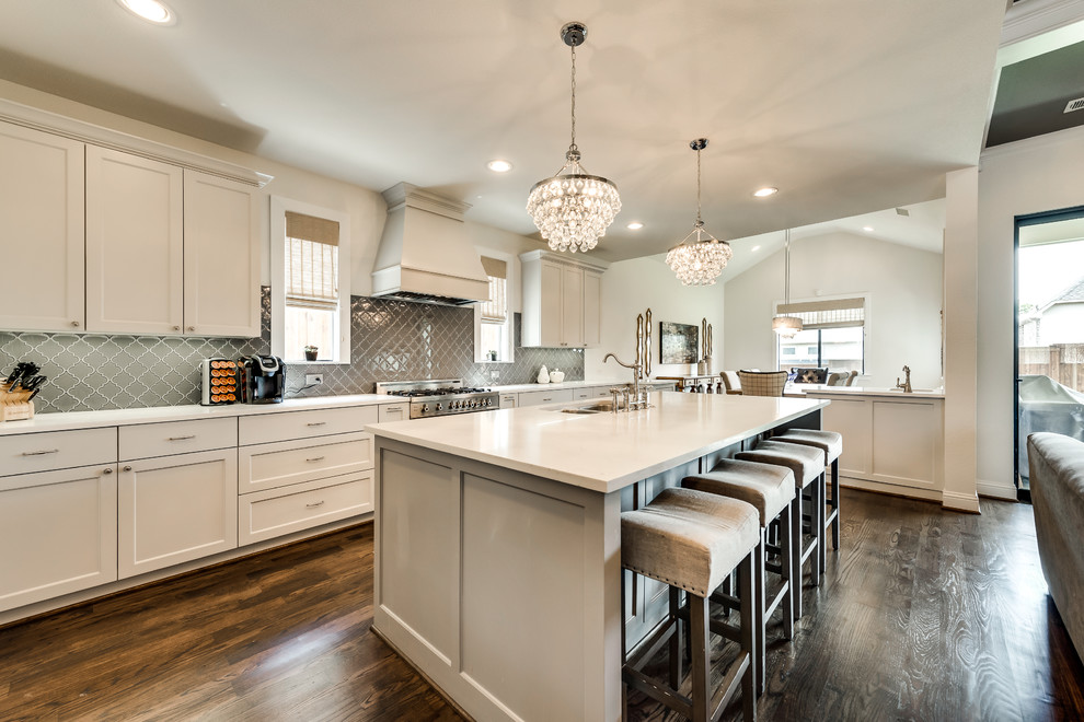 Inspiration for a large classic l-shaped open plan kitchen in Dallas with shaker cabinets, grey cabinets, grey splashback, porcelain splashback, stainless steel appliances, dark hardwood flooring, an island, brown floors, a double-bowl sink and composite countertops.