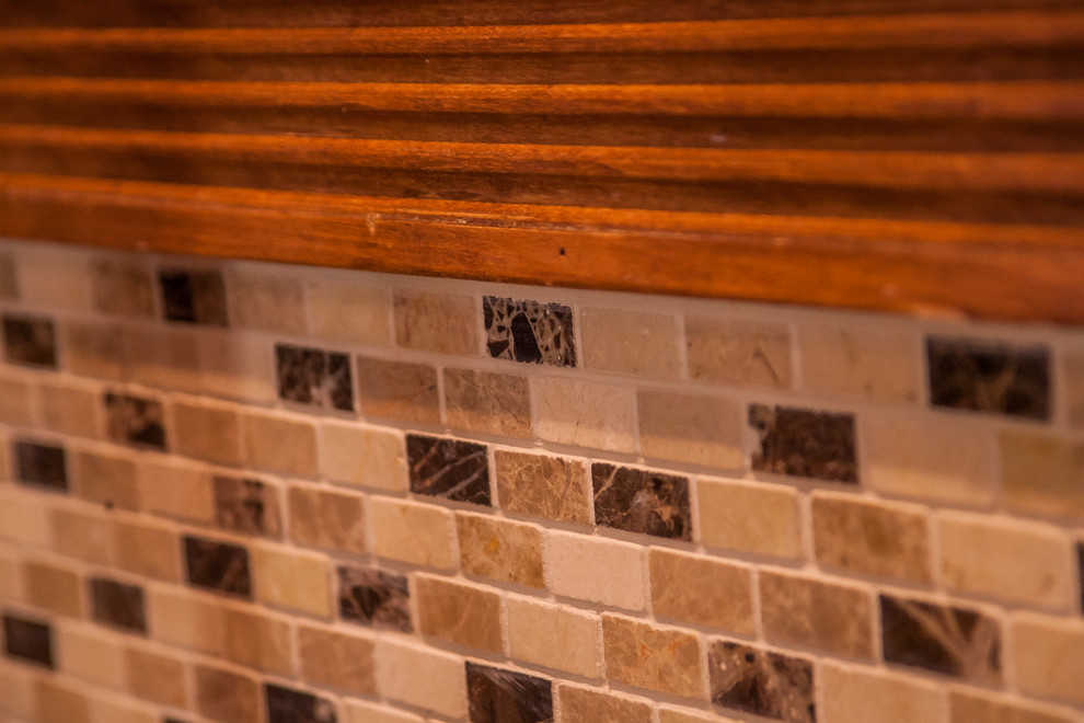Foto på ett stort vintage kök, med en undermonterad diskho, luckor med infälld panel, skåp i mellenmörkt trä, granitbänkskiva, flerfärgad stänkskydd, stänkskydd i mosaik, rostfria vitvaror, mellanmörkt trägolv, en köksö och brunt golv