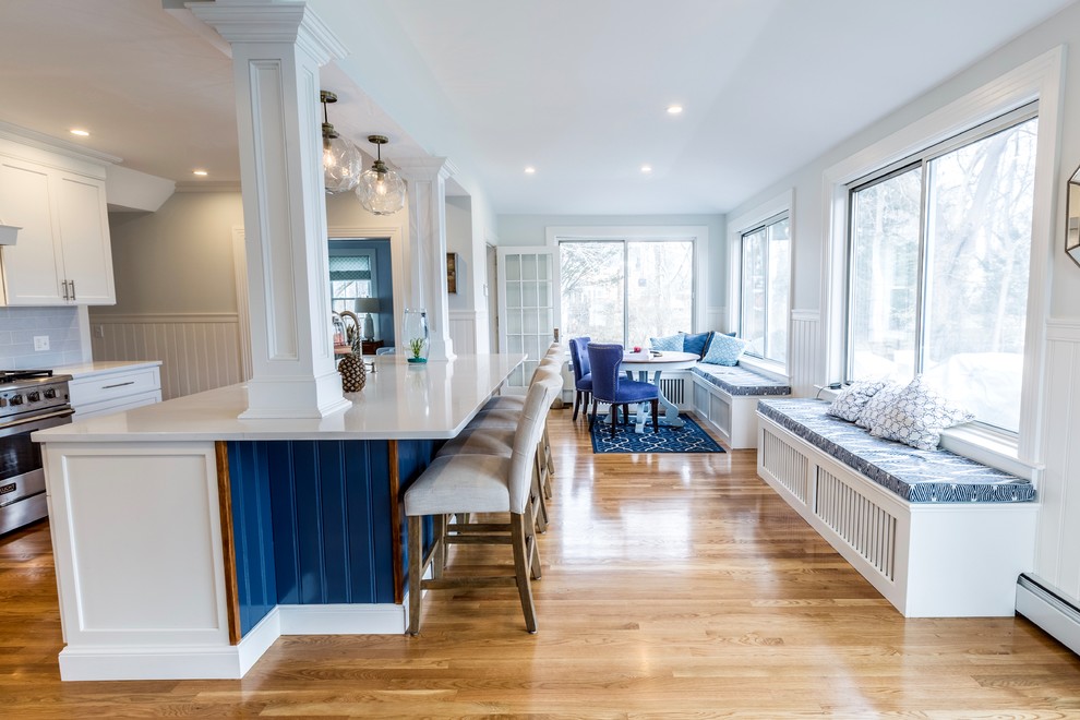 Inspiration for an expansive traditional l-shaped kitchen/diner in Providence with a submerged sink, recessed-panel cabinets, white cabinets, quartz worktops, blue splashback, porcelain splashback, stainless steel appliances, medium hardwood flooring, an island and brown floors.