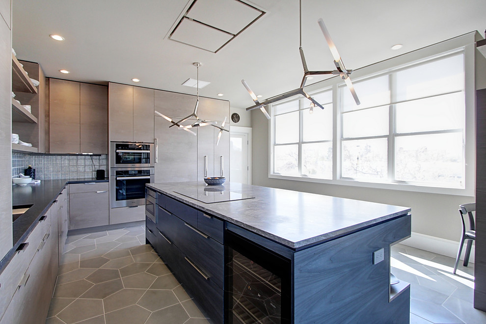 Mid-sized minimalist l-shaped concrete floor and gray floor enclosed kitchen photo in Denver with an undermount sink, flat-panel cabinets, brown cabinets, granite countertops, gray backsplash, paneled appliances, an island and multicolored countertops