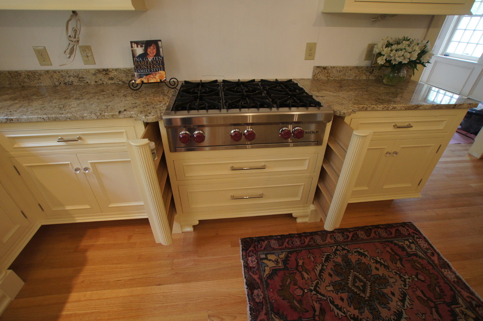 Diseño de cocina comedor tradicional con armarios con rebordes decorativos, puertas de armario de madera clara y encimera de granito