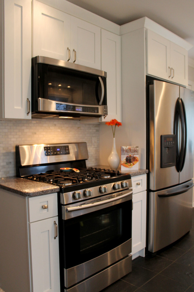 Foto på ett litet funkis kök, med en undermonterad diskho, skåp i shakerstil, vita skåp, bänkskiva i kvartsit, vitt stänkskydd, stänkskydd i tunnelbanekakel, rostfria vitvaror, en köksö och skiffergolv
