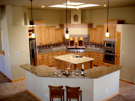 Mediterrane Küche in L-Form mit profilierten Schrankfronten, hellen Holzschränken, Granit-Arbeitsplatte, bunter Rückwand, Rückwand aus Mosaikfliesen, Küchengeräten aus Edelstahl, Porzellan-Bodenfliesen und Kücheninsel in Albuquerque