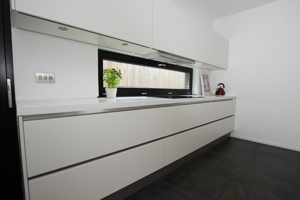 Medium sized contemporary kitchen in London with an island and mirror splashback.