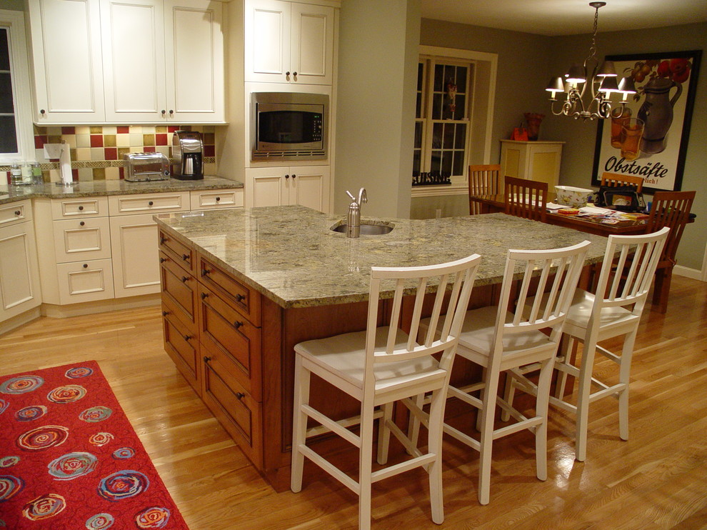 Inspiration for a mid-sized timeless eat-in kitchen remodel in Boston with an undermount sink, recessed-panel cabinets, white cabinets, granite countertops, red backsplash and an island
