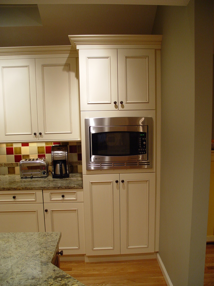 Exempel på ett mellanstort klassiskt kök och matrum, med en undermonterad diskho, luckor med infälld panel, vita skåp, granitbänkskiva, rött stänkskydd och en köksö