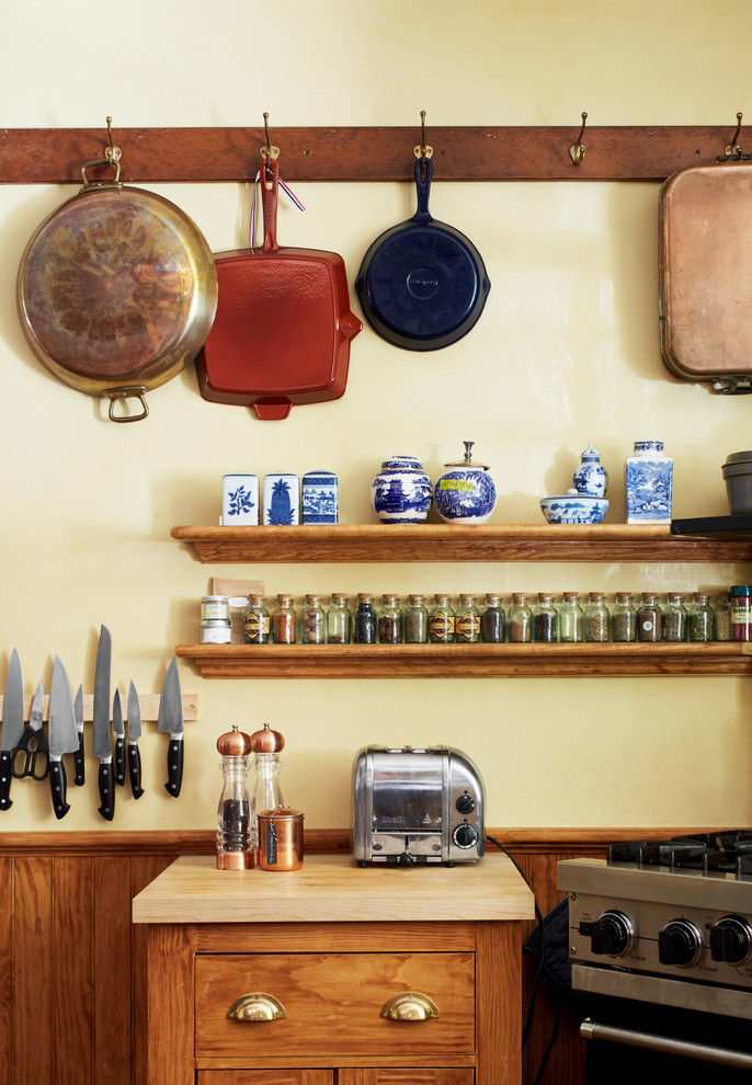 Foto på ett vintage kök, med skåp i mellenmörkt trä, rostfria vitvaror och öppna hyllor