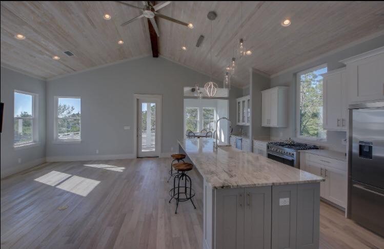 Ispirazione per una grande cucina stile marinaro con lavello stile country, ante in stile shaker, ante bianche, top in marmo, paraspruzzi blu, paraspruzzi con piastrelle di vetro, elettrodomestici in acciaio inossidabile, pavimento in gres porcellanato e pavimento grigio