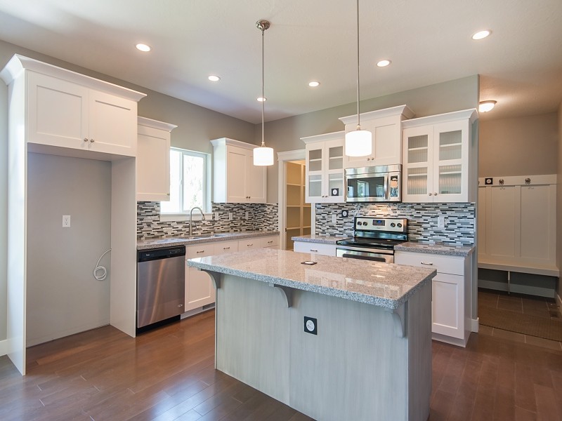 Large arts and crafts u-shaped medium tone wood floor eat-in kitchen photo in Salt Lake City with a double-bowl sink, flat-panel cabinets, white cabinets, granite countertops, gray backsplash, ceramic backsplash and an island