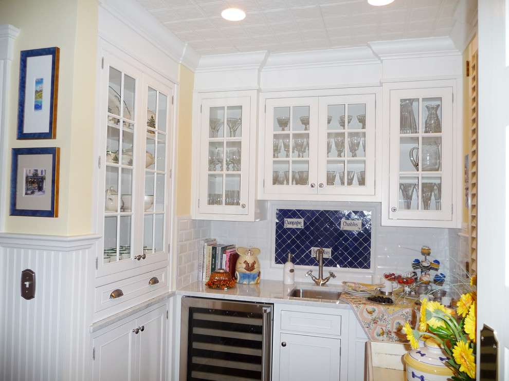Inspiration for a timeless l-shaped eat-in kitchen remodel in New York with a farmhouse sink, recessed-panel cabinets, white cabinets, marble countertops, white backsplash, subway tile backsplash and stainless steel appliances
