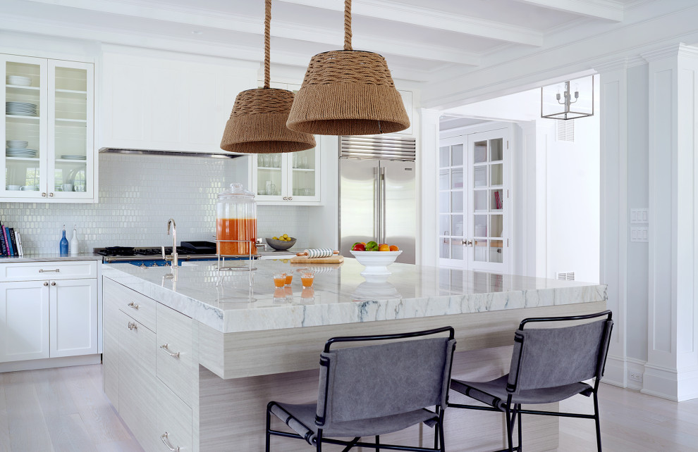 Nautical l-shaped kitchen in New York with white cabinets, white splashback, light hardwood flooring, an island, beige floors, white worktops, a belfast sink, shaker cabinets, marble worktops and coloured appliances.