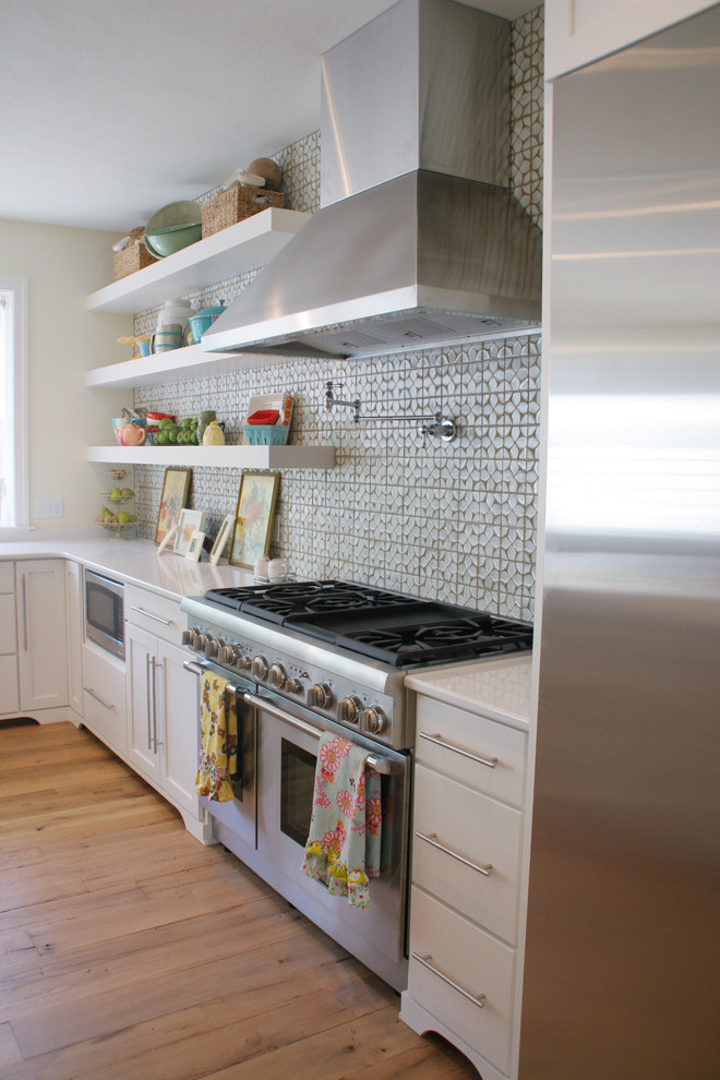 Diseño de cocina ecléctica con armarios abiertos, puertas de armario blancas, salpicadero verde y electrodomésticos de acero inoxidable