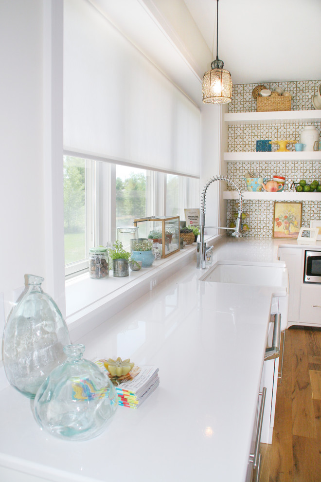 Пример оригинального дизайна: кухня в стиле фьюжн с с полувстраиваемой мойкой (с передним бортиком), белыми фасадами и мойкой у окна