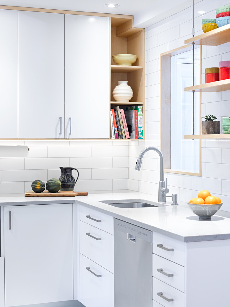 Small danish l-shaped porcelain tile eat-in kitchen photo in Toronto with an undermount sink, flat-panel cabinets, white cabinets, quartz countertops, white backsplash, subway tile backsplash, stainless steel appliances and a peninsula