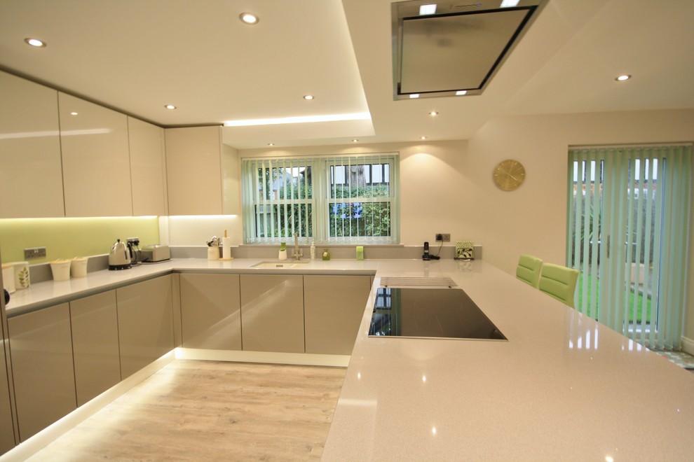 Inspiration for a large contemporary u-shaped kitchen/diner in Essex with a single-bowl sink, flat-panel cabinets, grey cabinets, quartz worktops, stainless steel appliances and no island.