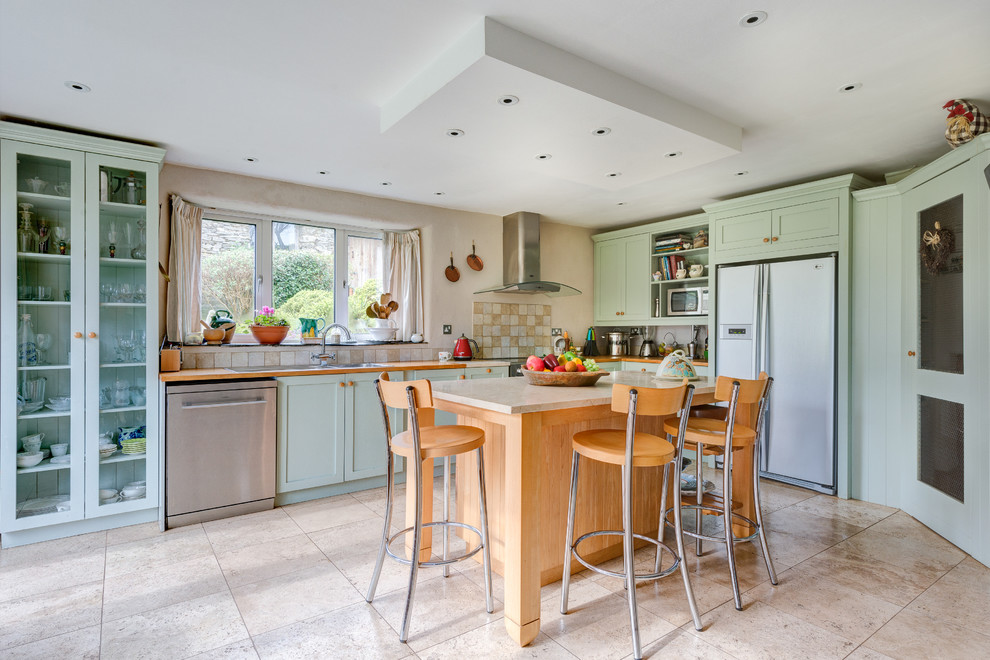 Mittelgroße Landhaus Küche in L-Form mit Schrankfronten im Shaker-Stil, grünen Schränken, Arbeitsplatte aus Holz, Küchenrückwand in Beige und Küchengeräten aus Edelstahl in Devon