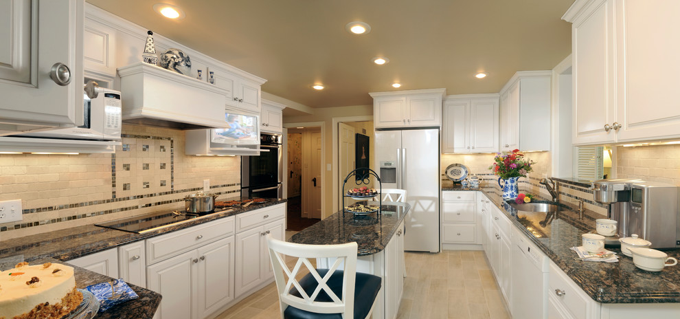 Inspiration for a small timeless u-shaped ceramic tile enclosed kitchen remodel in Other with an undermount sink, raised-panel cabinets, white cabinets, granite countertops, beige backsplash, mosaic tile backsplash, stainless steel appliances and an island