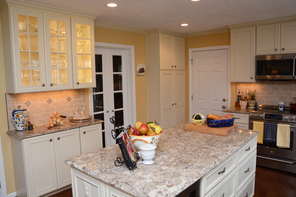 Bild på ett stort beige beige kök, med en undermonterad diskho, luckor med infälld panel, beige skåp, bänkskiva i kvarts, beige stänkskydd, rostfria vitvaror, mörkt trägolv, en köksö och brunt golv