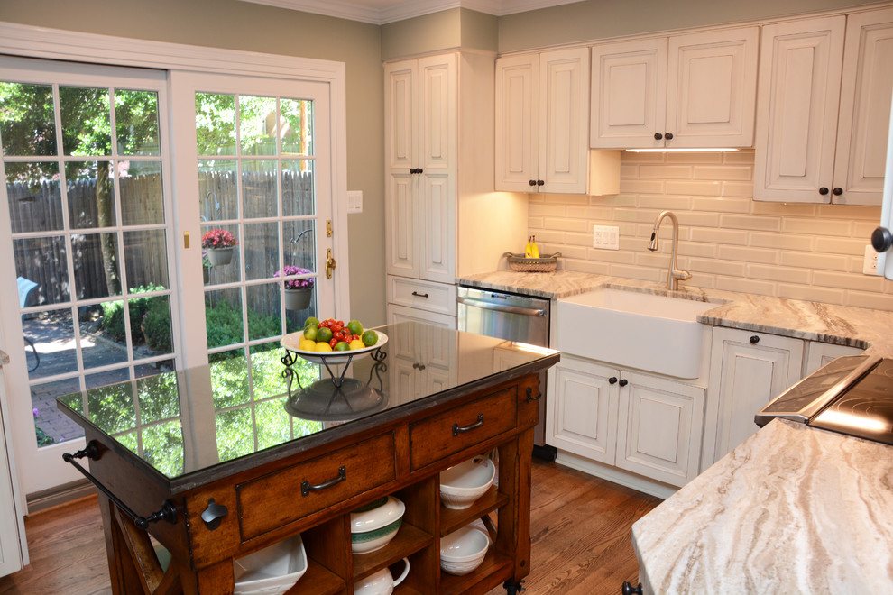 Exempel på ett avskilt, mellanstort klassiskt beige beige l-kök, med en rustik diskho, luckor med upphöjd panel, beige skåp, granitbänkskiva, beige stänkskydd, stänkskydd i mosaik, rostfria vitvaror, mellanmörkt trägolv, en köksö och brunt golv