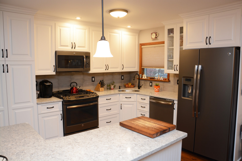 Idéer för mellanstora vintage vitt kök, med en undermonterad diskho, luckor med upphöjd panel, vita skåp, bänkskiva i kvarts, beige stänkskydd, stänkskydd i porslinskakel, rostfria vitvaror, mellanmörkt trägolv, en köksö och brunt golv