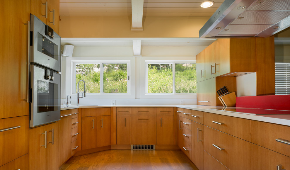 Exempel på ett mellanstort modernt kök, med en undermonterad diskho, släta luckor, skåp i mellenmörkt trä, bänkskiva i kvartsit, vitt stänkskydd, rostfria vitvaror, mellanmörkt trägolv och en halv köksö