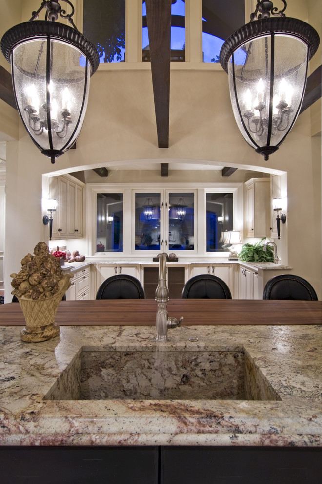 На фото: кухня в классическом стиле с монолитной мойкой и барной стойкой с