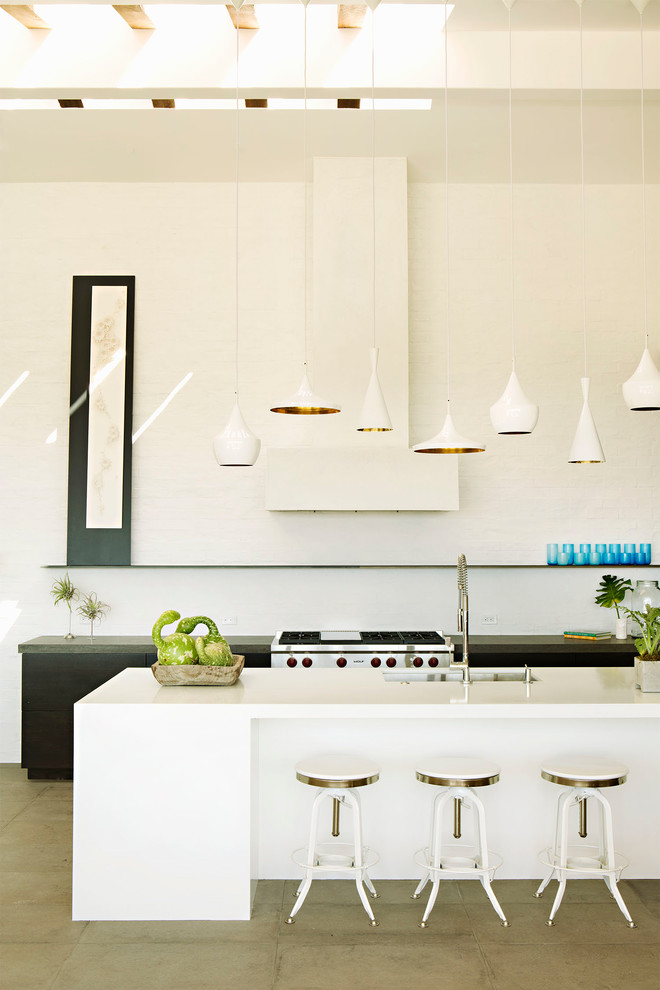 На фото: кухня в современном стиле с врезной мойкой, плоскими фасадами, черными фасадами, белым фартуком, техникой из нержавеющей стали и серым полом с