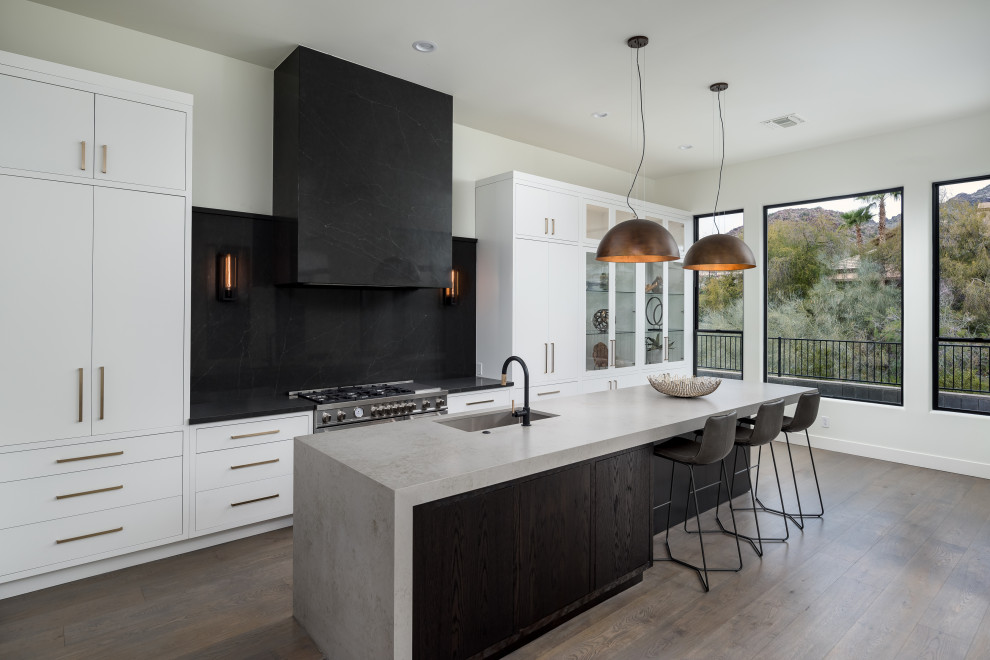 Kitchen - modern l-shaped medium tone wood floor kitchen idea in Phoenix with flat-panel cabinets, quartz countertops, stone slab backsplash and stainless steel appliances
