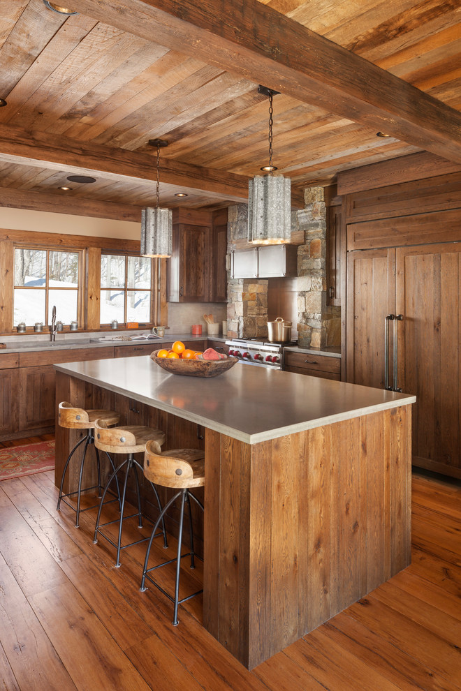 Design ideas for a large rustic l-shaped kitchen in Boston with a submerged sink, shaker cabinets, dark wood cabinets, integrated appliances, medium hardwood flooring, an island, composite countertops and brown floors.