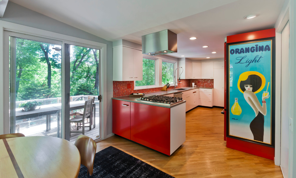 На фото: параллельная кухня среднего размера в современном стиле с обеденным столом, врезной мойкой, плоскими фасадами, красными фасадами, столешницей из кварцевого агломерата, разноцветным фартуком, цветной техникой, паркетным полом среднего тона и полуостровом