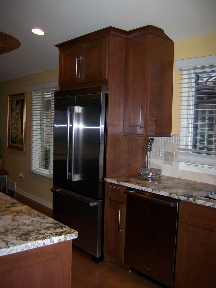 Exemple d'une cuisine ouverte chic en L et bois brun avec un évier encastré, un placard à porte shaker, un plan de travail en granite, une crédence beige et un électroménager en acier inoxydable.