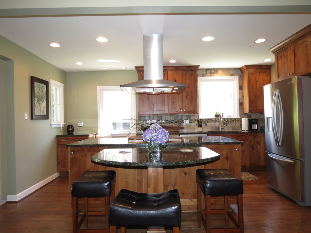 Example of a mountain style l-shaped eat-in kitchen design in Detroit with an undermount sink, flat-panel cabinets, medium tone wood cabinets, granite countertops, multicolored backsplash, stone tile backsplash and stainless steel appliances