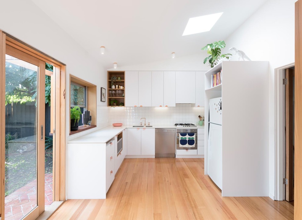 Kleine Skandinavische Küche mit weißen Schränken, Arbeitsplatte aus Terrazzo, Küchenrückwand in Weiß, Rückwand aus Keramikfliesen, hellem Holzboden und weißer Arbeitsplatte in Melbourne