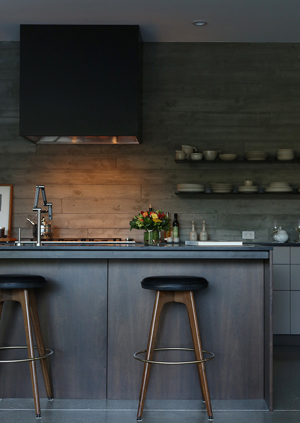 Réalisation d'une cuisine ouverte minimaliste en L et bois foncé de taille moyenne avec un placard à porte plane, un électroménager en acier inoxydable, sol en béton ciré et îlot.