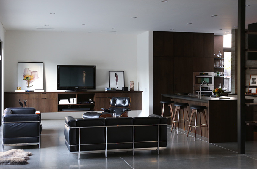 This is an example of a medium sized modern l-shaped open plan kitchen in San Francisco with flat-panel cabinets, dark wood cabinets, stainless steel appliances, concrete flooring and an island.