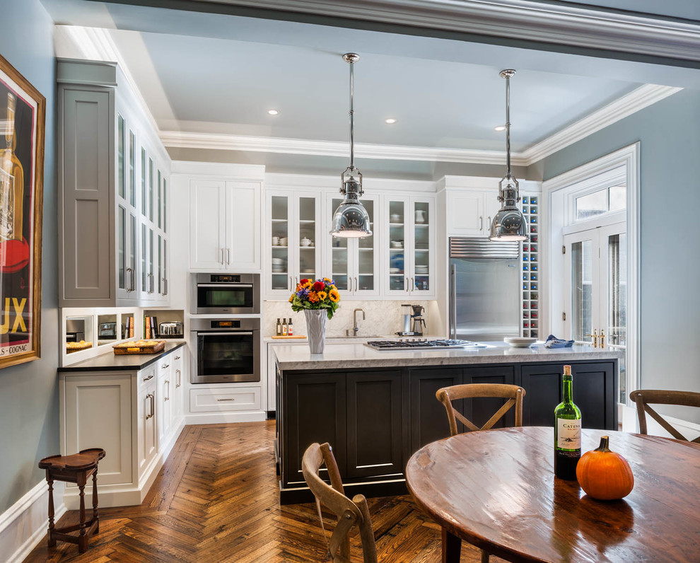 Example of a classic eat-in kitchen design in Philadelphia with shaker cabinets, white cabinets, granite countertops, stainless steel appliances and white backsplash