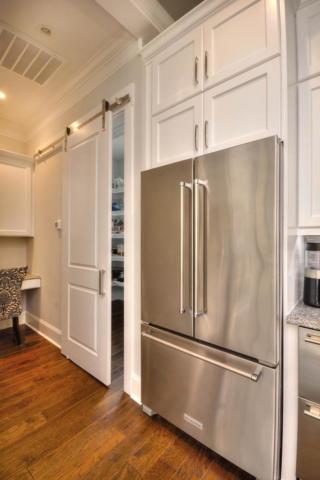 Bild på ett stort vintage grå grått kök, med en undermonterad diskho, skåp i shakerstil, vita skåp, granitbänkskiva, grått stänkskydd, stänkskydd i stickkakel, rostfria vitvaror, mellanmörkt trägolv, en köksö och brunt golv