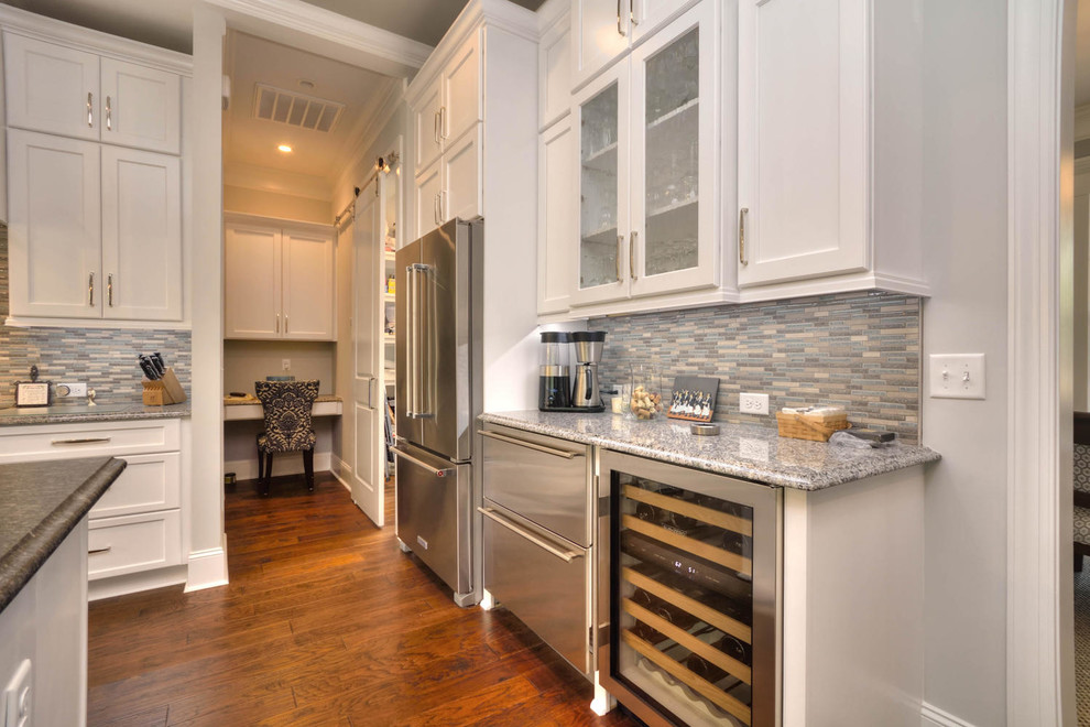Large transitional l-shaped medium tone wood floor and brown floor open concept kitchen photo in Other with an undermount sink, shaker cabinets, white cabinets, granite countertops, gray backsplash, matchstick tile backsplash, stainless steel appliances, an island and gray countertops